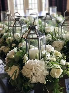 the centerpieces are filled with white flowers and greenery, along with candles