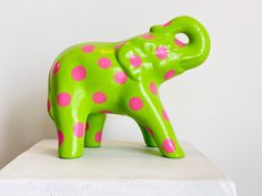 a green elephant statue with pink polka dots on it