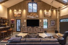 a living room with couches, chairs and a flat screen tv mounted on the wall