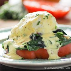 a close up of a plate of food with cheese and vegetables on it, including tomatoes