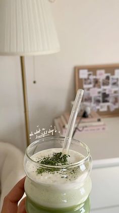 a person holding a drink in their hand with a straw sticking out of the top