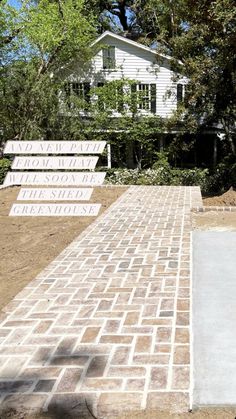 a skateboarder doing a trick in the air on a brick walkway near a house