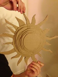 a person is holding up a cardboard sun