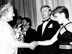 an old black and white photo of two women shaking hands with one man in a tuxedo