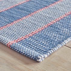 a blue and red rug on top of a wooden floor next to a wood floor