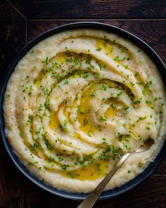 mashed potatoes with butter and chives in a bowl on a wooden table top