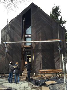 two people standing outside of a building under construction