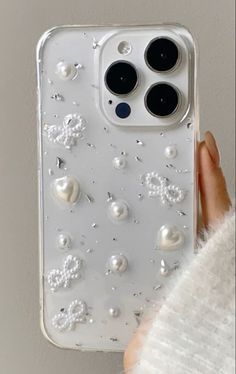 a person holding an iphone case with pearls on it