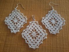 three white crocheted doily earrings hanging from hooks