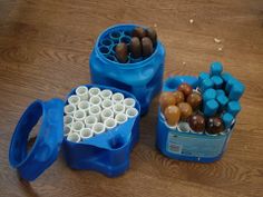 two plastic containers filled with different types of chocolates and marshmallows on a wooden table