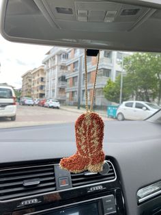 a pair of boots hanging from the dashboard of a car