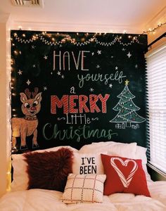 a christmas themed bedroom with chalkboard wall and lights on the headboard, decorated with festive pillows