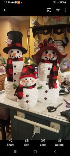 two snowmen made out of paper plates sitting on top of a kitchen counter next to each other