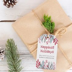 a brown package with a tag on it sitting next to pine cones and evergreen branches