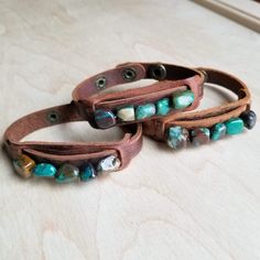 Genuine chunks of African Turquoise is sewn on to a genuine leather cuff with two adjustable snaps. Please note, all stones are genuine. They come in a variety of shapes and colors shown in multiple pictures. Entire length of bracelet is 3/4" by 9" Adjusts with snaps from Approx. 7.25" to 7.75" Although your bracelet will resemble the photo, each piece is created by hand, so no two are identical.Thank you for visiting The Jewelry Junkie! Leather Cuff Bracelet Diy, Leather Accessories Diy, Cuff Bracelets Diy, Leather Bracelet Tutorial, Stylish Leather Bags, Leather Wrist Cuff, Leather Jewelry Making, Handmade Leather Jewelry, Diy Leather Bracelet