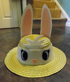 a white hat with ears and eyes on top of a brown floor next to stairs