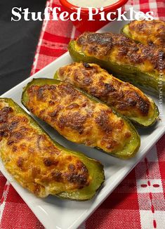 stuffed green peppers on a white plate next to a red and white checkered tablecloth