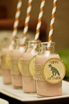 there are four bottles with pink liquid and straws in them that say happy birthday