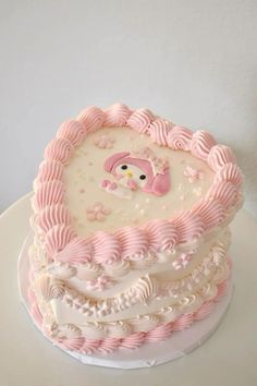 a pink and white cake with an owl on top