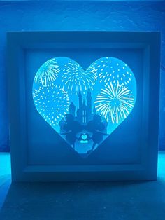 a heart shaped box with fireworks in the sky and castle on it's side