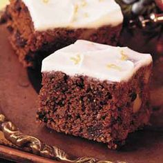 two pieces of brownie with white frosting on a plate