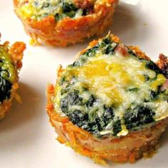 three mini quiches with spinach and cheese on them sitting on a white plate