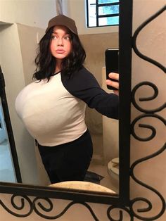 a pregnant woman taking a selfie in the mirror