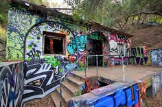 an abandoned building with graffiti all over it's walls and steps leading up to the entrance