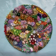 there is a large plate made out of many different beads and jewels on the surface