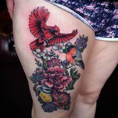 a woman's thigh with flowers and birds on it