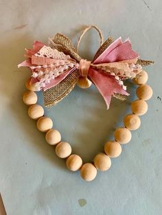 a heart shaped wooden bead necklace with a pink bow