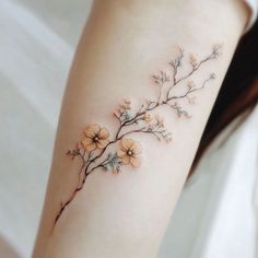 a woman's arm with small flowers on the left side of her body,