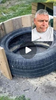 a man is standing next to an old tire