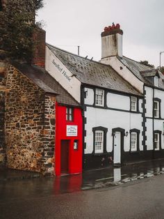 a white and black building with red door in the middle of it's street