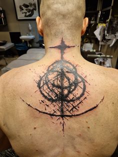 the back of a man's neck with an abstract tattoo design on his chest