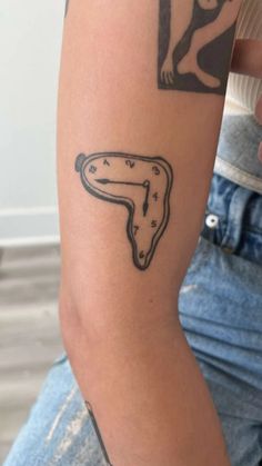 a person with a tattoo on their arm that has a clock in the shape of a horse's head