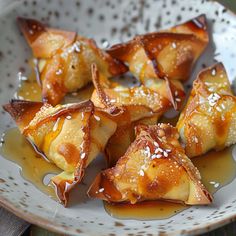 some food is sitting on a plate with sauce and sesame sprinkled around it