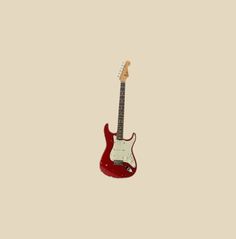 a red electric guitar hanging from the side on a beige background with room for text