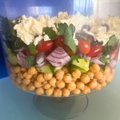 a glass bowl filled with vegetables and chickpeas