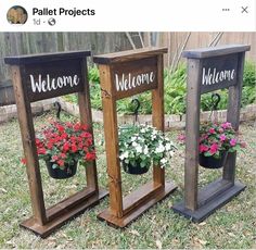 three wooden planters with flowers in them sitting on the grass next to each other