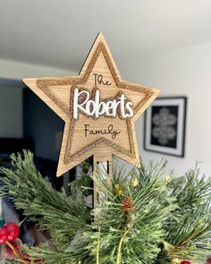 a wooden star ornament that says the roberts family on top of a christmas tree