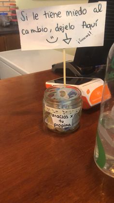 a sign that is sitting on top of a table next to a jar with toothbrushes in it