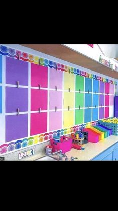 a colorful wall with lots of magnets on it in a kitchen area next to a sink