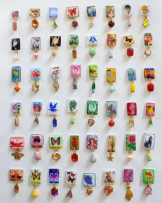 a white wall covered in lots of different types of brooches