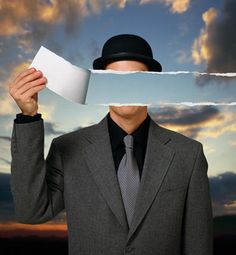 a man in a suit and tie holding up a piece of paper to his face