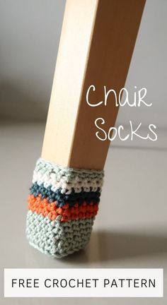 a pair of crocheted socks sitting on top of a wooden block with text overlay