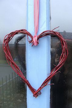 a heart shaped wreath hanging on the side of a door