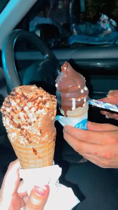 two people eating ice cream cones in the back seat of a car, one with chocolate and sprinkles