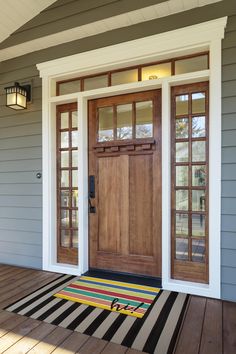 a front porch with two doors and a welcome mat