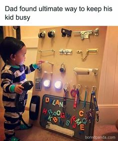 a little boy standing in front of a wall with keys on it